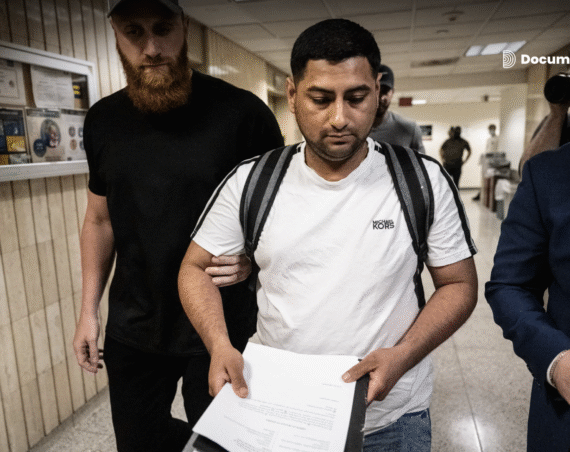 Agentes de ICE en los pasillos del 26 Federal Plaza detienen a un inmigrante el 6 de junio de 2025 en la ciudad de Nueva York. En su mano lleva los documentos de la corte.