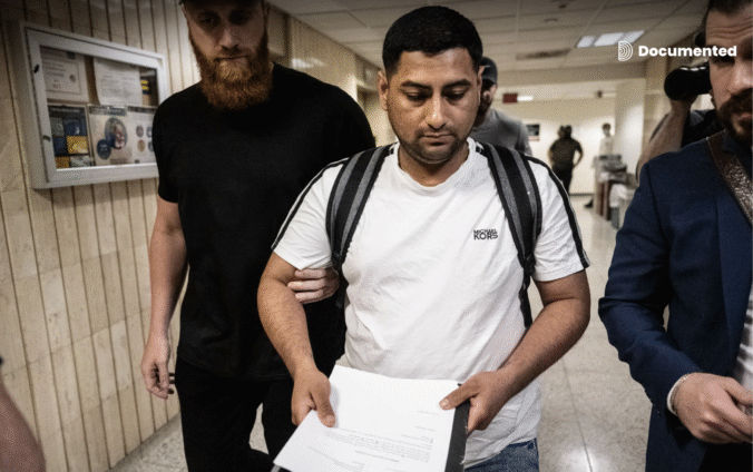 Agentes de ICE en los pasillos del 26 Federal Plaza detienen a un inmigrante el 6 de junio de 2025 en la ciudad de Nueva York. En su mano lleva los documentos de la corte.