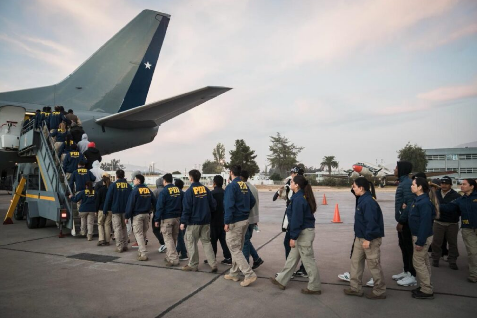 Oficiales de la PDI de Chile abordando un avión.