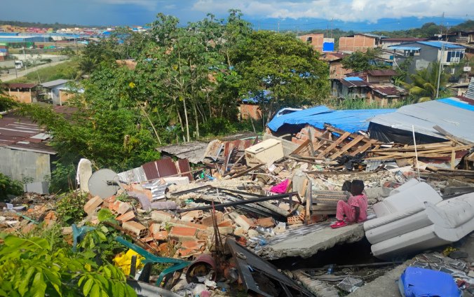 Un niño del barrio La Carmelita (Buenaventura) está sentado sobre los escombros de una casa vecina.