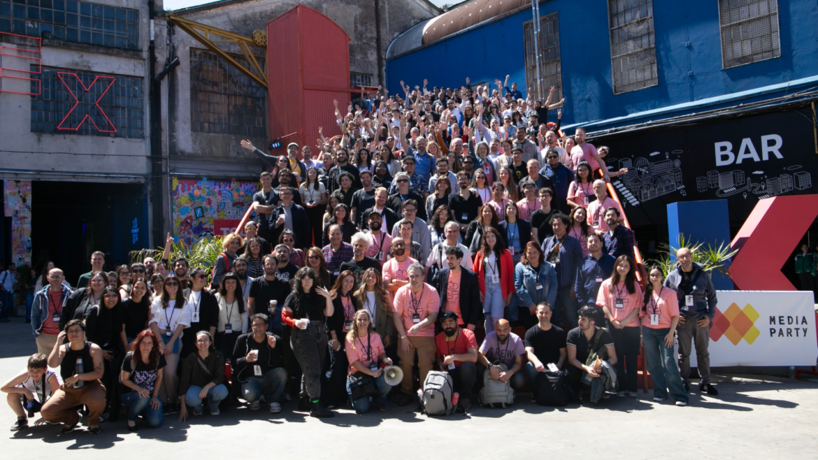 Foto grupal de cientos de participantes de Media Party en las escaleras de la Ciudad Cultural Konex, muchos con los brazos en alto