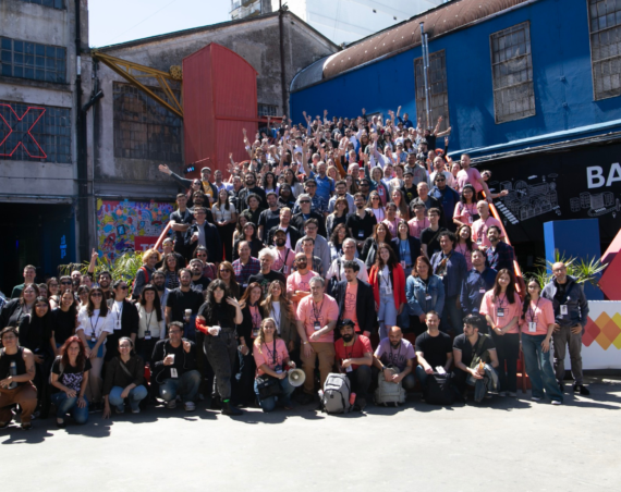 Foto grupal de cientos de participantes de Media Party en las escaleras de la Ciudad Cultural Konex, muchos con los brazos en alto