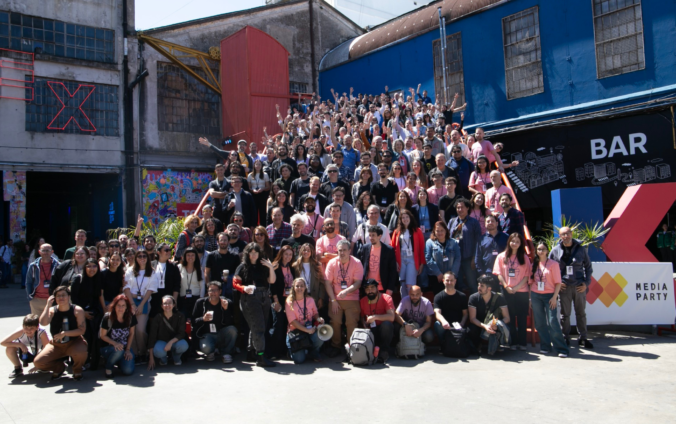 Foto grupal de cientos de participantes de Media Party en las escaleras de la Ciudad Cultural Konex, muchos con los brazos en alto